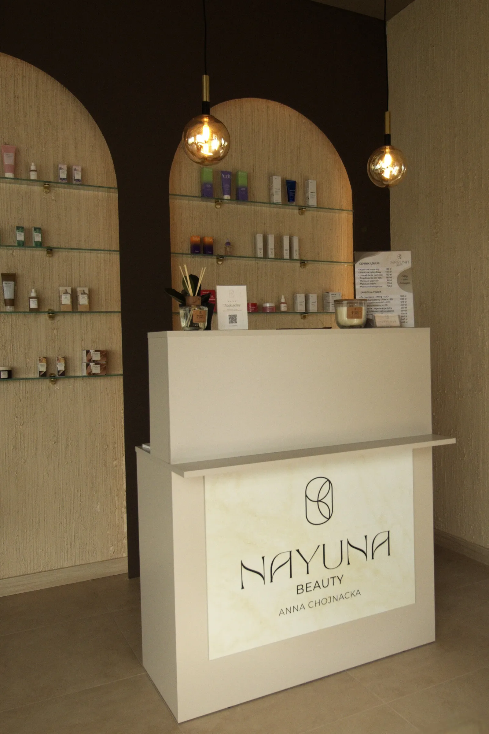 Półki z kosmetykami przy recepcji salonu NAYUNA Beauty
